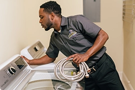 Technician holding washing machine hose.