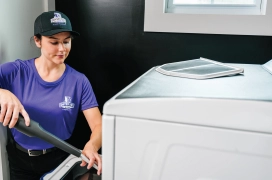 Female dryer vent pro cleaning out a residential dryer lint screen and trap.