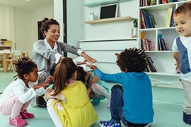 Woman with young children in classroom.